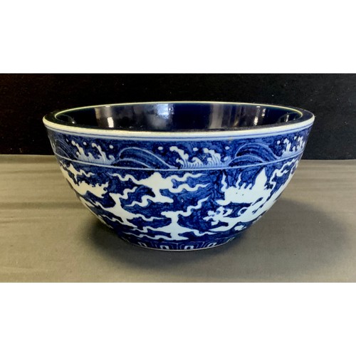 4 - A modern Chinese blue and white bowl, decorated with Dragons amongst clouds,, deep blue and white to... 