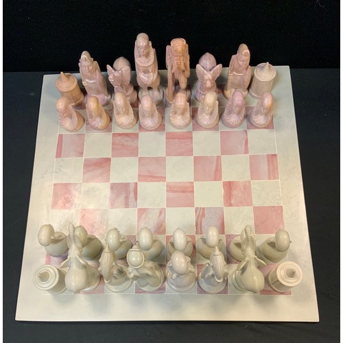 43 - A carved and polished African soap and specimen stone chess set with board.