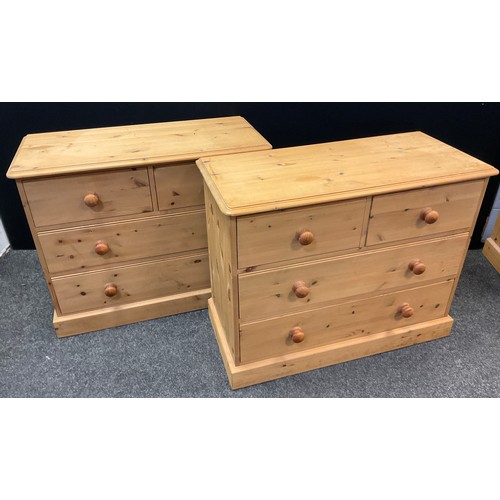 49 - A pair of pine four drawer chests, each with rounded oversailing tops, two short over three long dra... 