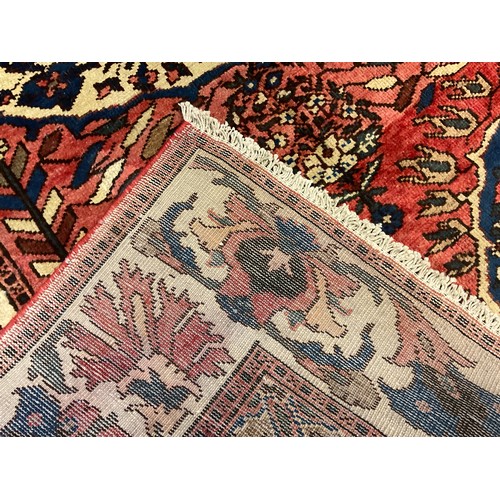 54 - A central Persian Bakhtiar rug / carpet, hand-knotted in muted tones of red, blue, and cream, 209cm ... 