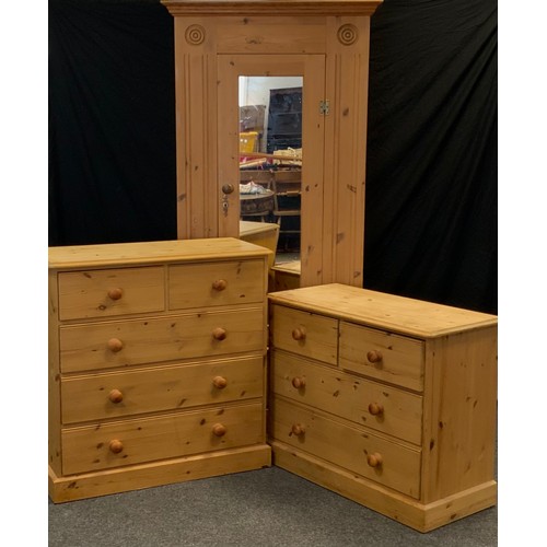 55 - A pine three piece bedroom suite, comprising single door wardrobe, with carved roundel detailed corn... 