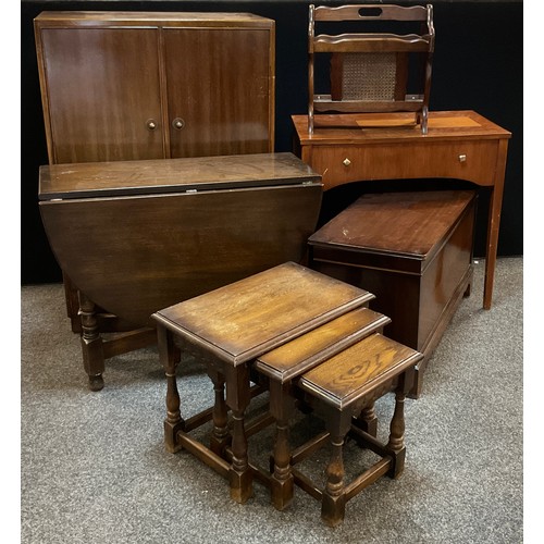 58 - A Graduated nest of three oak tables, mid 20th Canterbury, Sewing machine table, dark oak dropleaf t... 