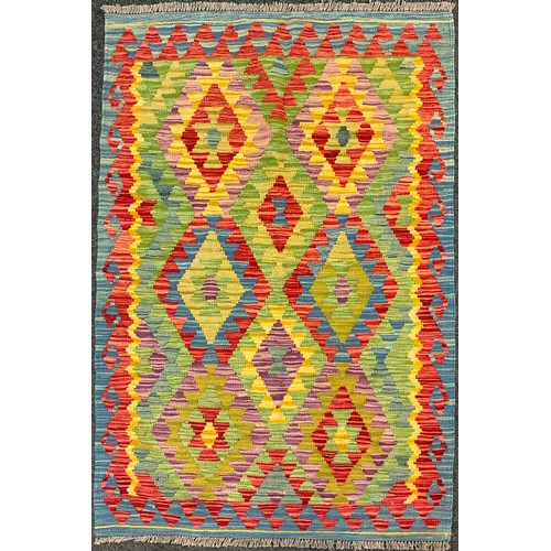 61 - A Turkish Anatolian Kilim rug, knotted in bright colours, with a repeating geometric pattern, in red... 