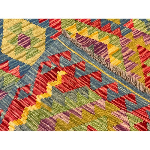 61 - A Turkish Anatolian Kilim rug, knotted in bright colours, with a repeating geometric pattern, in red... 