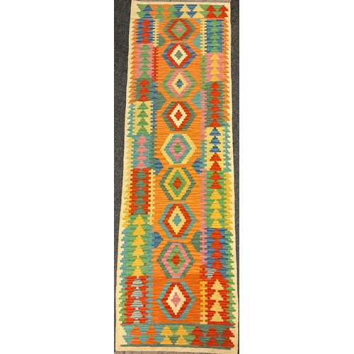 72 - A Turkish Anatolian Kilim runner carpet, knotted with a central row of nine diamond-shaped medallion... 