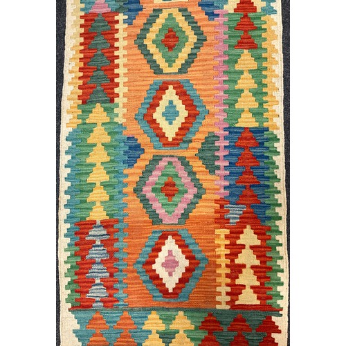 72 - A Turkish Anatolian Kilim runner carpet, knotted with a central row of nine diamond-shaped medallion... 