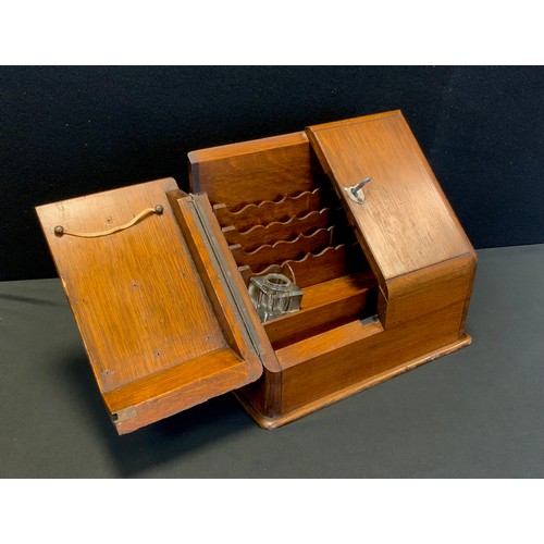 84 - A twentieth century oak stationary box, hinged doors, fitted interior, lock and key, 30cm high x 33c... 