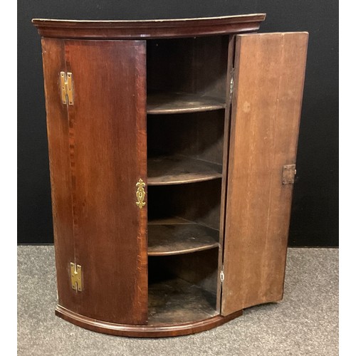 161 - A early 20th century mahogany corner cupboard; cross banded doors with three interior shelves. 103cm... 