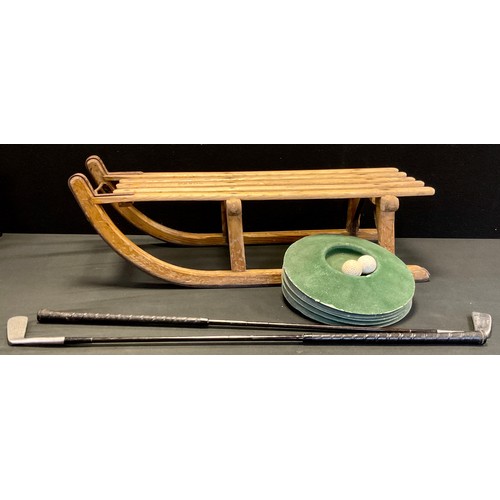 176 - A Davos sledge; a putting set comprising two putter and five holes