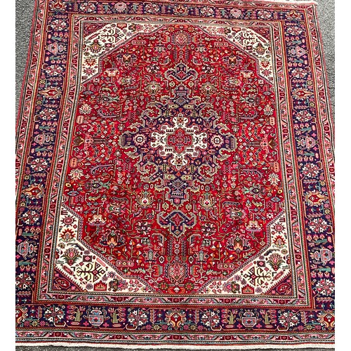 183 - A North West Persian Heriz carpet, hand-knotted with a central diamond-form medallion, within a fiel... 