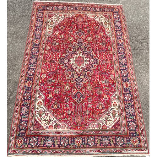 183 - A North West Persian Heriz carpet, hand-knotted with a central diamond-form medallion, within a fiel... 