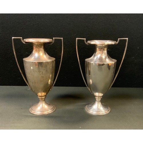 243 - A pair of silver twin handled spill vases, London, c.1824, weighted base, 932.7 grams gross (2)