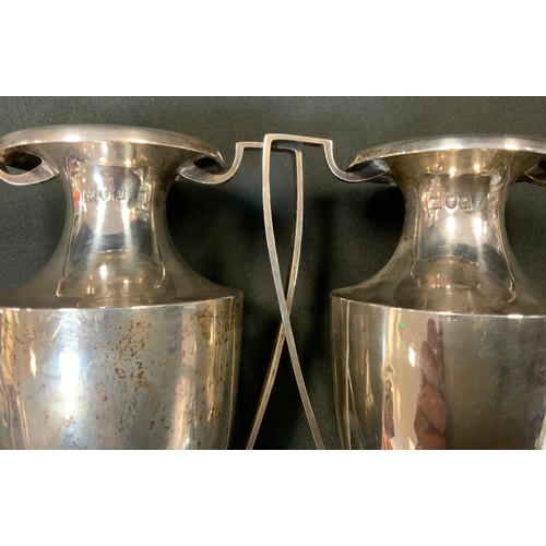 243 - A pair of silver twin handled spill vases, London, c.1824, weighted base, 932.7 grams gross (2)