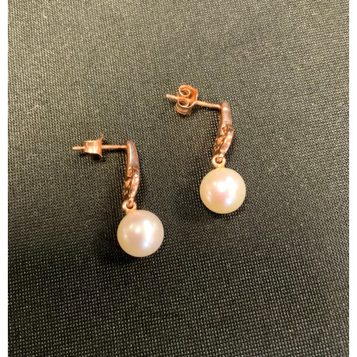 251 - A pair of diamond and pearl rose gold earrings, rose gold bar and loop drops, accented with sixteen ... 