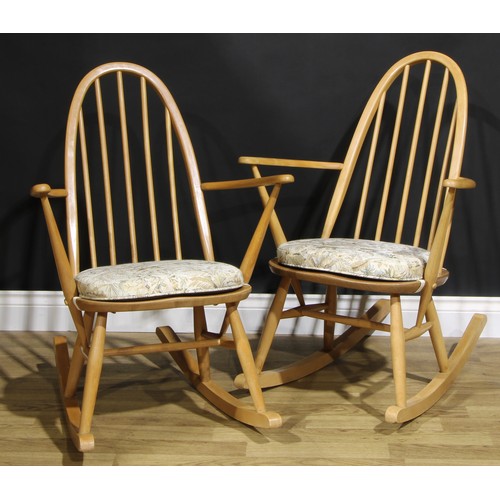 451 - A pair of mid 20th century Ercol ‘Blonde’ Elm spindle-back rocking chairs, each 91cm high (2)