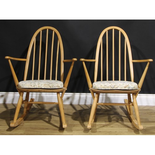 451 - A pair of mid 20th century Ercol ‘Blonde’ Elm spindle-back rocking chairs, each 91cm high (2)