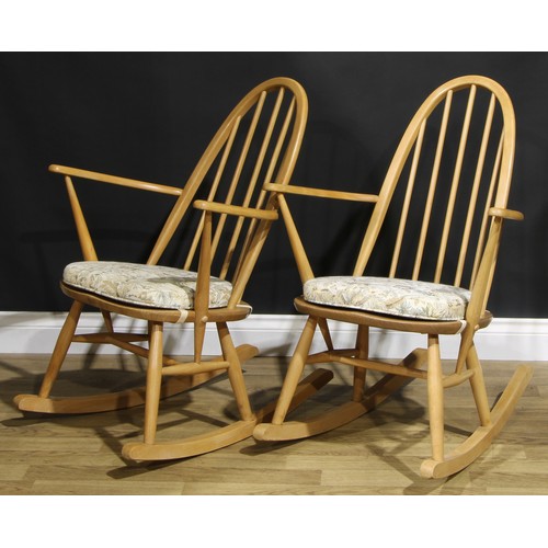 451 - A pair of mid 20th century Ercol ‘Blonde’ Elm spindle-back rocking chairs, each 91cm high (2)