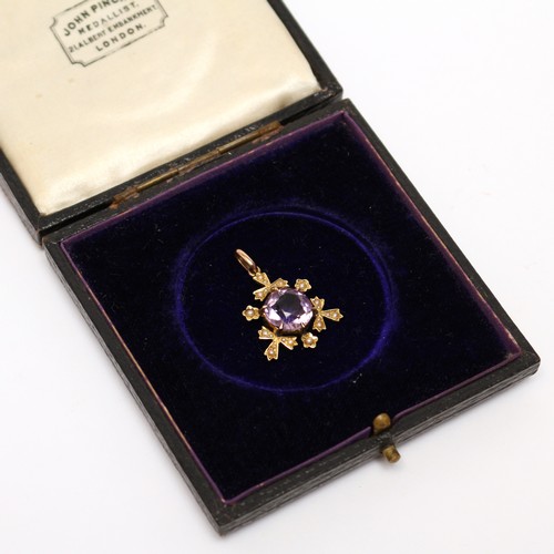 480 - An Edwardian 16ct gold pendant, set with a single faceted amethyst, the border flanked with seed pea... 