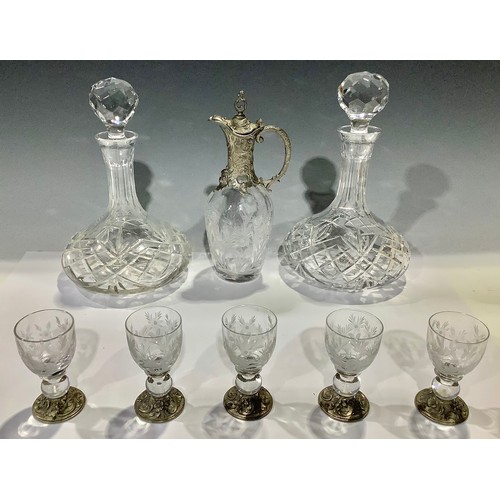 483 - A cut glass ship's decanter; another; a pewter mounted wine decanter and five conforming glasses