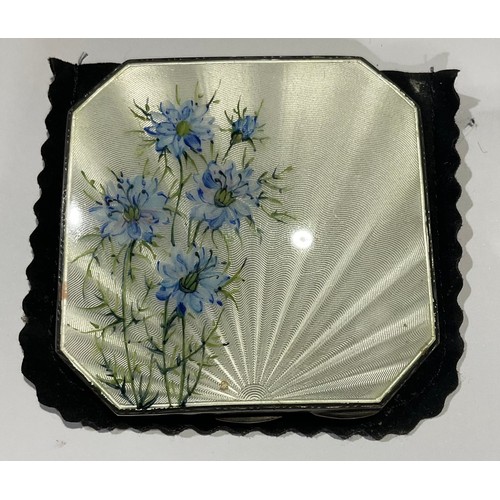 501 - A silver and engine turned white enamel canted square compact, decorated with cornflowers, hinged co... 