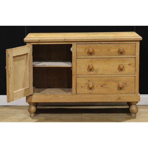 107 - A Victorian pine low dresser, of three drawers neighboured by a panel door, enclosing a shelf, turne... 