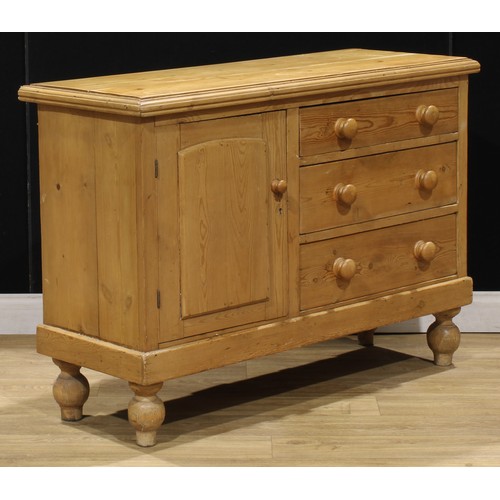 107 - A Victorian pine low dresser, of three drawers neighboured by a panel door, enclosing a shelf, turne... 