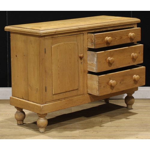 107 - A Victorian pine low dresser, of three drawers neighboured by a panel door, enclosing a shelf, turne... 