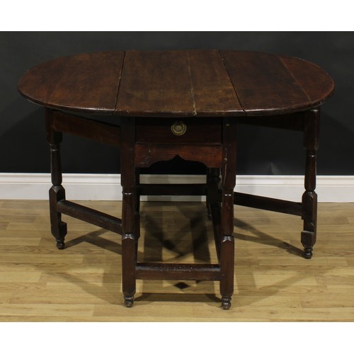 524 - An oak gateleg table, near-oval top with fall leaves, turned and blocked supports, 71cm high, 45cm o... 