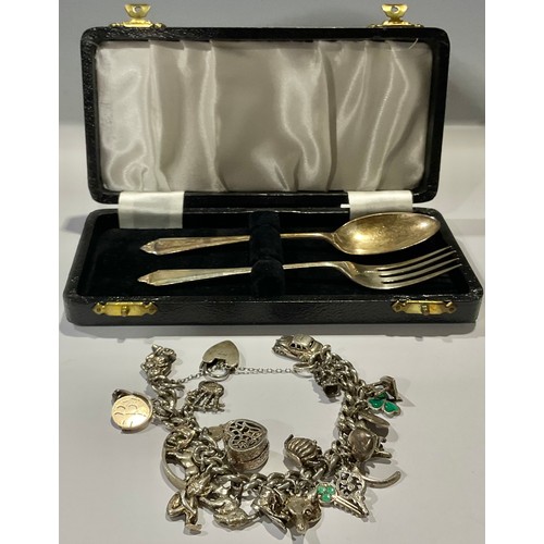 767 - A silver christening fork and spoon set, Birmingham 1958, 36g, cased; a silver curb link charm brace... 