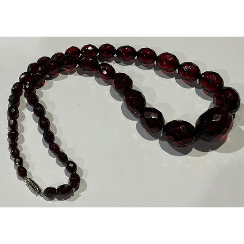 807 - A graduated set of oval facet cut cherry amber beads