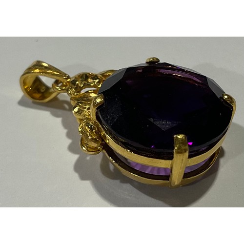 811 - A gold coloured metal mounted Amethyst pendant, the large circular single stone facet cut, claw set,... 