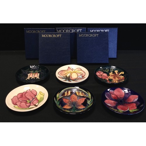 17 - Moorcroft Pottery - six circular dishes, each in a different pattern including Frangipani, Oberon, C... 
