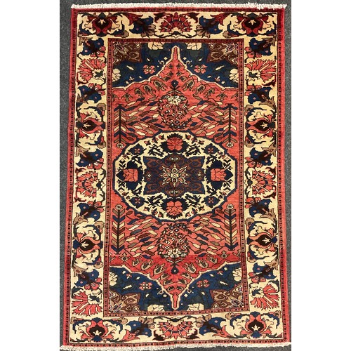 133 - A central Persian Bakhtiar rug / carpet, hand-knotted in muted tones of red, blue, and cream, 209cm ... 