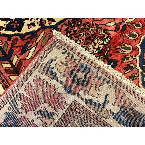 133 - A central Persian Bakhtiar rug / carpet, hand-knotted in muted tones of red, blue, and cream, 209cm ... 