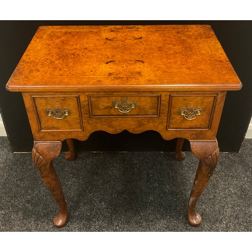 146 - A reproduction burr elm lowboy, oversailing top above three frieze drawers, shaped apron, shell carv... 