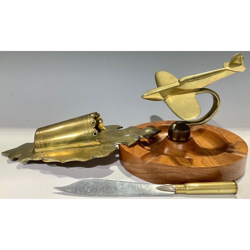 32 - Trench Art - a brass shell case wall pocket, pocket knife; a brass desk weight/ashtray as a plane (3... 
