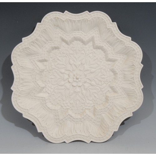 92 - A Royal Worcester parian shaped circular plate, moulded in the Orientalist taste with lotus, 30.5cm ... 