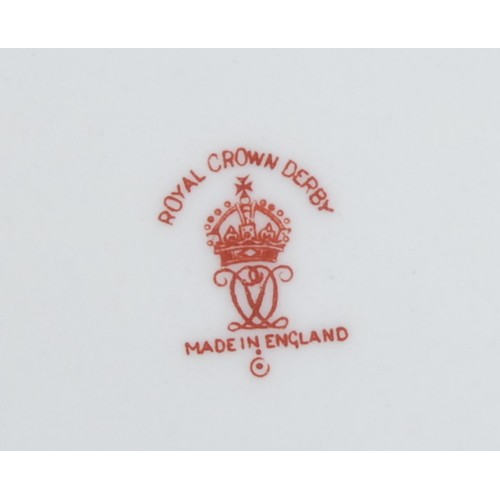 126 - A pair of Royal Crown Derby shaped circular plates, painted with central sprays of dog roses on crea... 