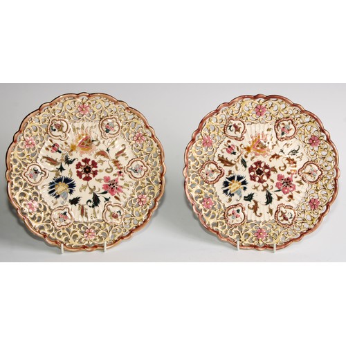 174 - A pair of Zsolnay Pecs shaped circular plates, each decorated in polychrome with stylised flowers, r... 