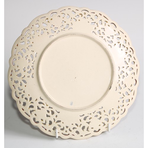 174 - A pair of Zsolnay Pecs shaped circular plates, each decorated in polychrome with stylised flowers, r... 