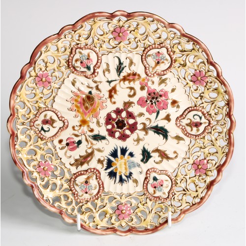 174 - A pair of Zsolnay Pecs shaped circular plates, each decorated in polychrome with stylised flowers, r... 