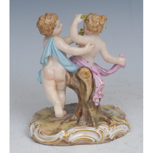 157 - A German porcelain figure group, putti suitors gathering blooms, 12cm high, impressed 2996, crossed ... 