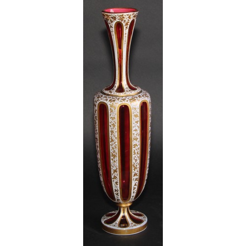 196 - A Bohemian overlaid ruby glass panelled ovoid vase, decorated in gilt with dense scrolling leaves, 3... 
