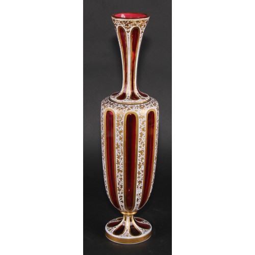 196 - A Bohemian overlaid ruby glass panelled ovoid vase, decorated in gilt with dense scrolling leaves, 3... 