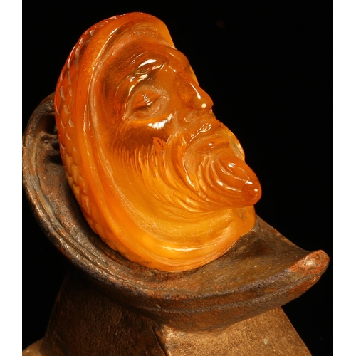 1272 - Alfred Lyndhurst Pocock (1882 - 1962), an amber carving, the head of a bearded man, sculpted terraco... 