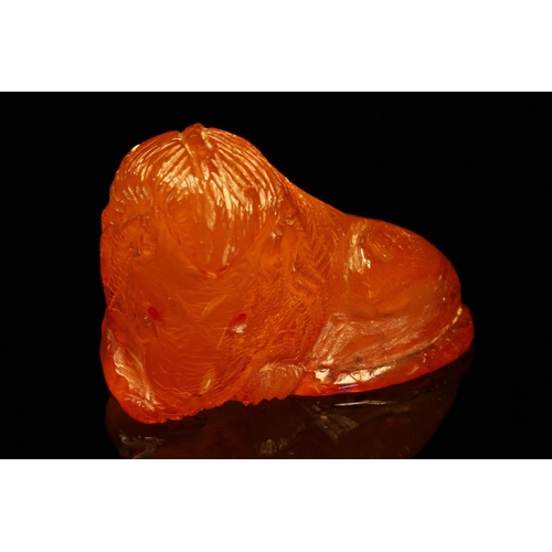 1267 - Alfred Lyndhurst Pocock (1882 - 1962), an amber carving, of a lion, ruby eyes, unsigned, 4cm wide