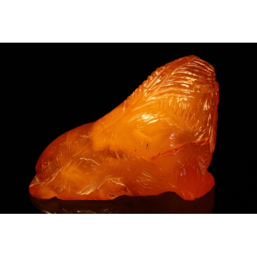 1267 - Alfred Lyndhurst Pocock (1882 - 1962), an amber carving, of a lion, ruby eyes, unsigned, 4cm wide