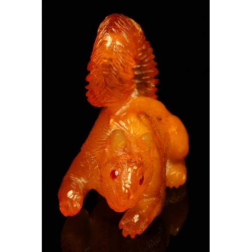 1268 - Alfred Lyndhurst Pocock (1882 - 1962), an amber carving, of a squirrel, ruby eyes, 5cm long, signed,... 