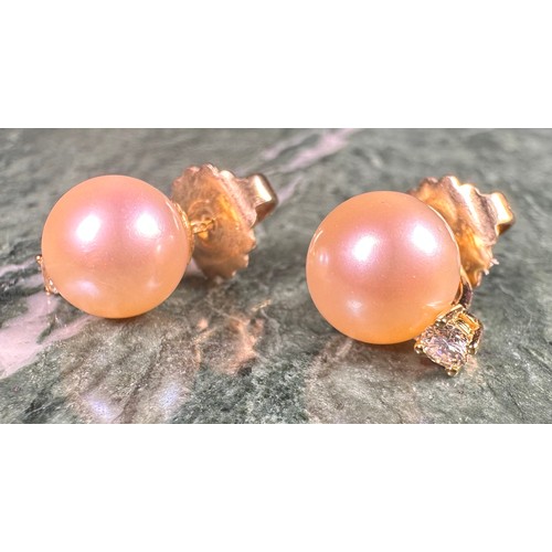 975 - A pair of diamond solitaire and cultured pearl earrings, each stone approximately 0.15ct, the stems ... 