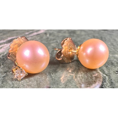 975 - A pair of diamond solitaire and cultured pearl earrings, each stone approximately 0.15ct, the stems ... 